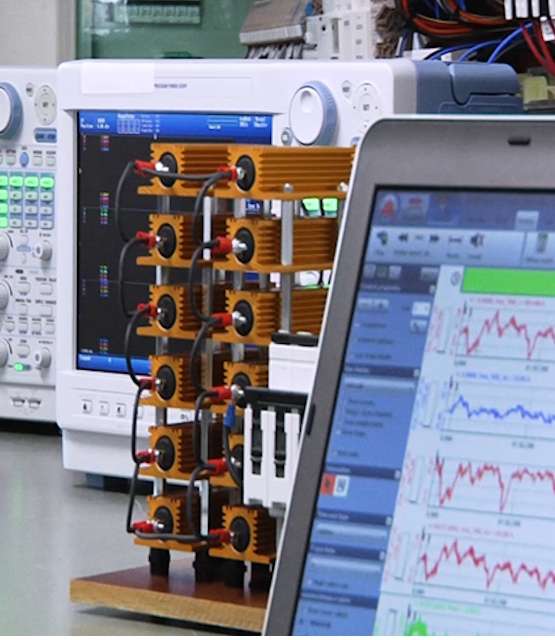 Een close-up van monitoring apparatuur met grafieken op een computerscherm in een laboratoriumomgeving.